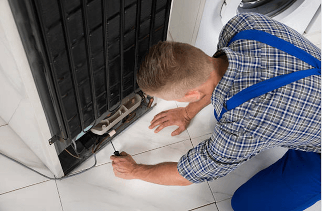 repairman fixing refrigerator